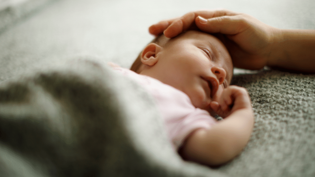 bebê recém-nascido dormindo com uma mão sobre sua cabeça